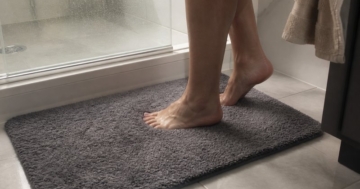 Badematte vor der Dusche auf den Fliesen